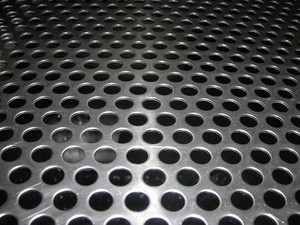 A piece of aluminum perforated metal sheet with round shape holes in staggered row patterns.